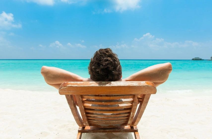 Person relaxing on beach chair by the ocean